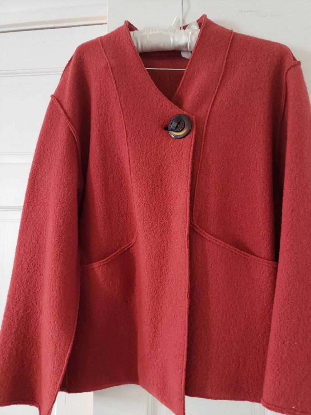Rust 100% boiled wool jacket with raglan sleeves, decorative button, and pockets